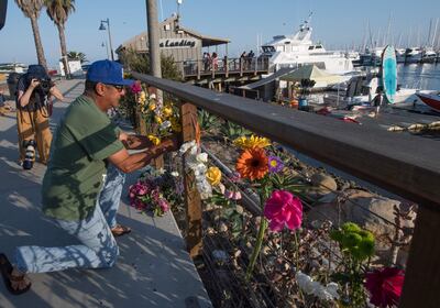 Un hombre deja flores en el memorial en honor a los fallecidos en el incendio.
