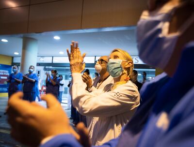 Trabajadores de salud españoles aplauden ante vítores de una multitud fuera del hospital Son Espases, en Palma de Mallorca.