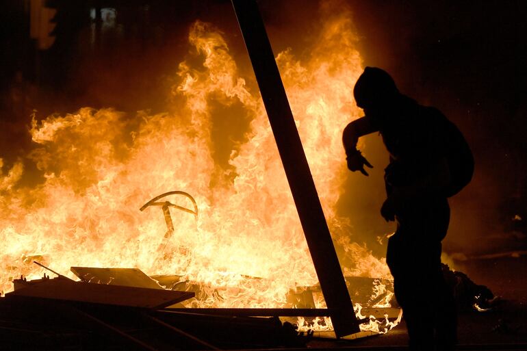 Un manifestante frente a una barricada en llamas durante los disturbios de este martes.