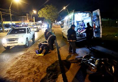 El paramédico tirado sobre el paseo central es asistido por uno de sus compañeros.