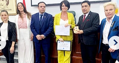 La exmodelo argentina Pamela David (centro) en el Salón Comuneros de Diputados. Con una medalla en la mano está Enrique Castro y Juan Carlos Amoroso (der.).