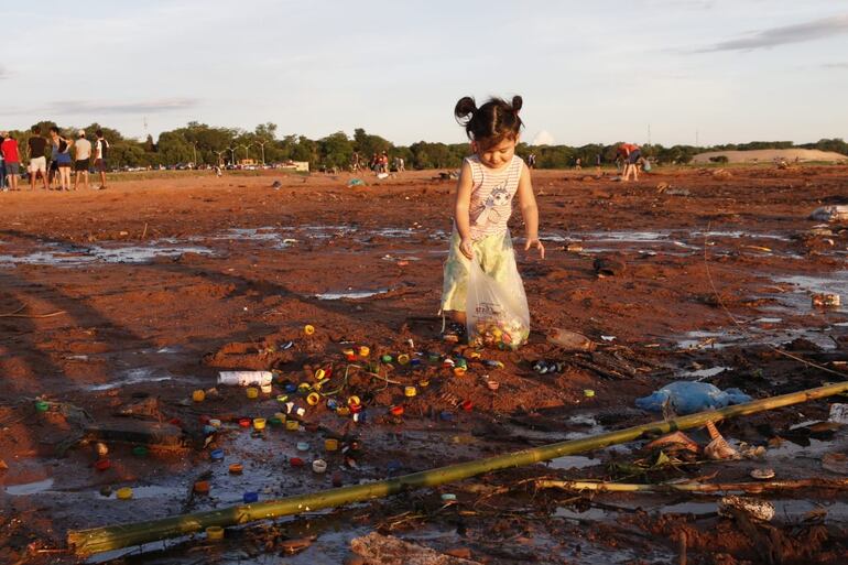 Una pequeña limpiando la rivera del río Paraguay en Limpio.