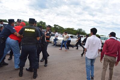 Policías intentan detener a manifestantes durante un cierre de ruta por parte de partidarios del diputado Miguel Cuevas, el martes en Paraguarí.