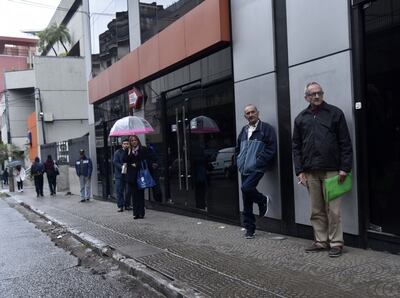 Personas esperan buses en el centro de Asunción.
