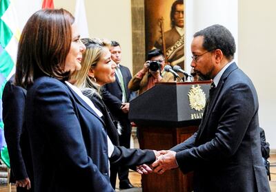 La presidente interina de Bolivia, Jeanine Áñez, recibe el saludo de un diplomático durante una recepción.