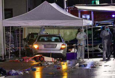 La policía forense investigan un auto plateado Mercedes Benz que atropelló a un grupo de participantes de un desfile de carnaval.