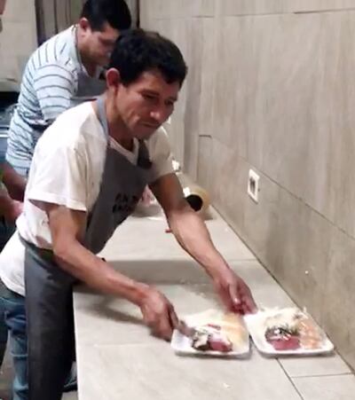 Uno de los internos prepara la bandeja de comida para sus compañeros.