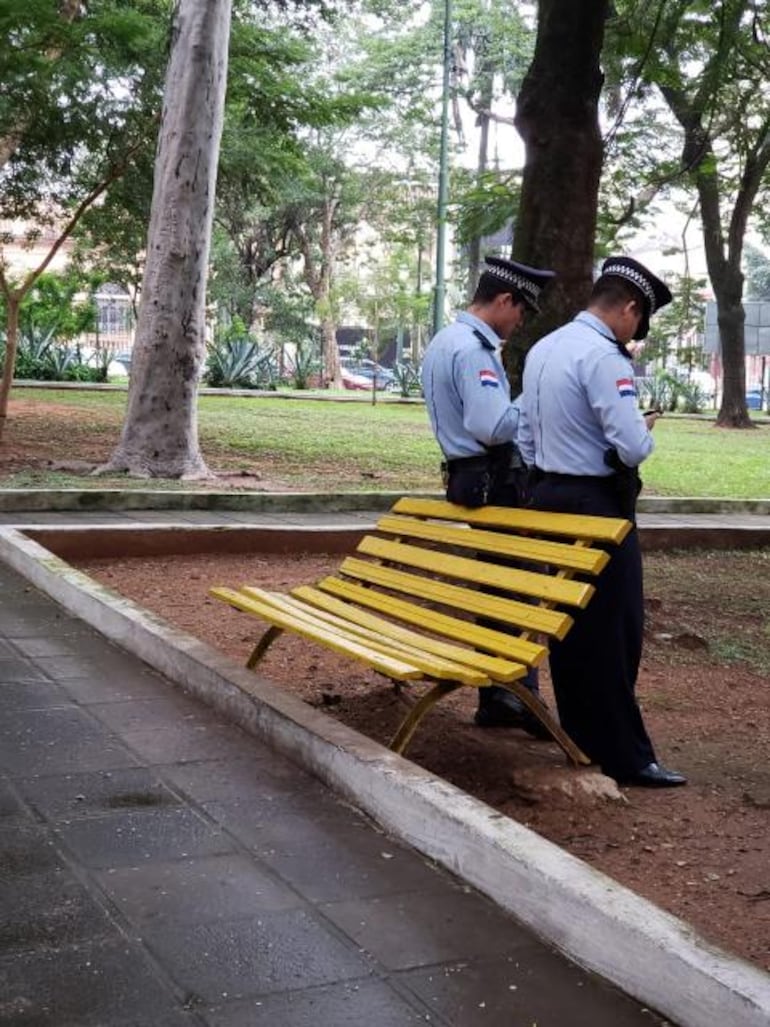 El tedio de la siesta parece haberse apoderado de estos agentes de la Policía Urbana, que pasan su guardia chateando en la Plaza Uruguaya.