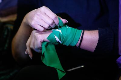 Una mujer ajusta en su muñeca un pañuelo verde a favor del aborto legal (Imagen referencial).