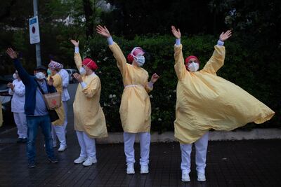 Trabajadores de la salud saludan fuera de un hospital en Barcelona, España.