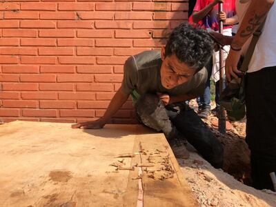 Uno de los ocupantes de la propiedad que pertenece a los Stroessner en Ciudad del Este observa los restos óseos hallados ayer en el finca. Los huesos deberán ser analizados por especialistas.