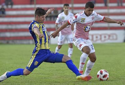 Ariel Coronel, de Capiatá, intenta frenar la marcha del juvenil Derlis Mereles, autor del empate para San Lorenzo.
