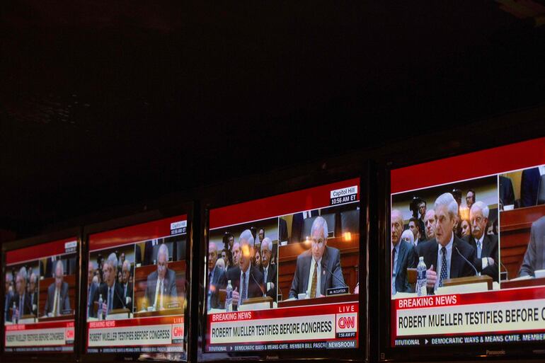 Varios televisores en un bar en Washington muestran la comparecencia de Robert Mueller ante el Congreso.