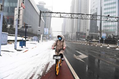 Una mujer circula en bicicleta en el distrito  financiero de Pekín.