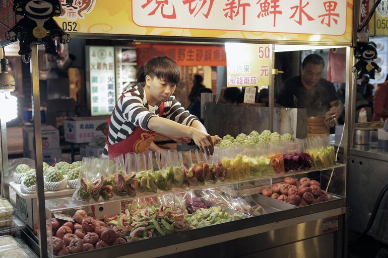 Se puede comprar prácticamente todo. Un vendedor decora frutas en el Ningxia Night Market de Taipei.