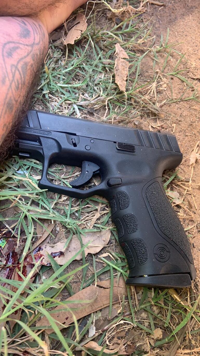 Arma de fuego encontrada al costado del cuerpo.