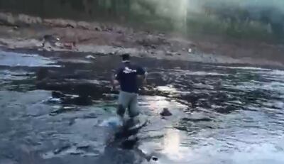 Momento en que un comunicador cruza a pie el brazo del río Paraná que rodea la Isla Acaray, situada a pocos metros del Puente de la Amistad.