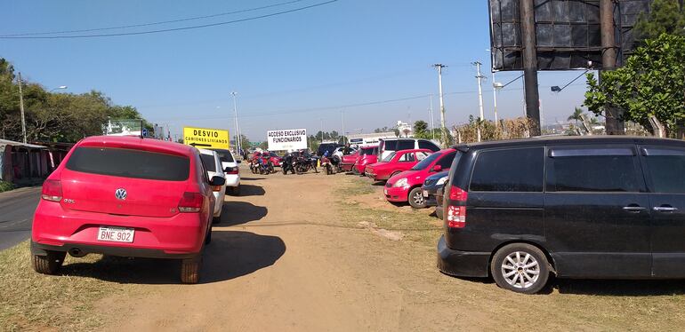 Fila de vehículos estacionados al costado de la calle América.