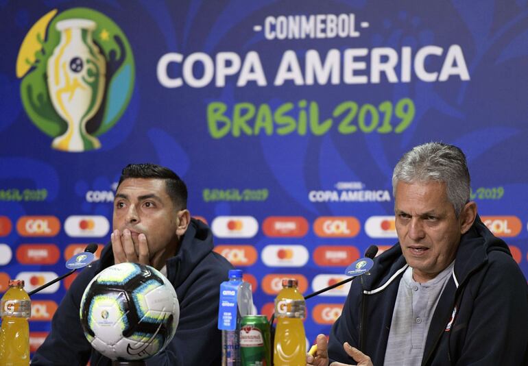Chile's coach Reinaldo Rueda (R) speaks next to defender Gonzalo Jara during the official presser at Arena do Gremio stadium in Porto Alegre, Rio Grande do Sul, Brazil on July 2, 2019 on the eve of the Copa America semifinal football match against Peru. (Photo by JUAN MABROMATA / AFP)