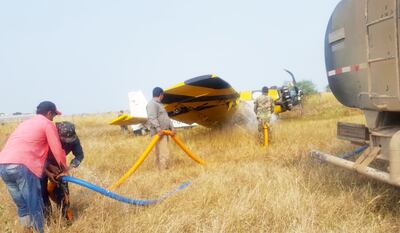 Personal de la estancia y militares  enfrían con agua el avión para evitar que se incendiara.