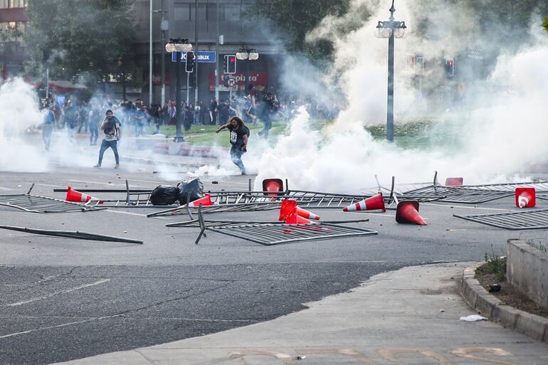 Las protestas por el alza del precio del tiquete del Metro de Santiago se extendieron a lo largo de este viernes por toda la ciudad con destrozos y actos violentos en las calles, lo que motivó el cierre de todas las líneas del suburbano y dejó a miles de personas sin forma de movilizarse.