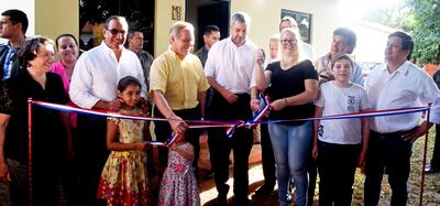 Mario Abdo desata la cinta en el acto de inauguración de viviendas sociales en J. Augusto Saldívar,  Central. Observan Hugo Javier González (izq.) y Dany Durand (camisa amarilla).