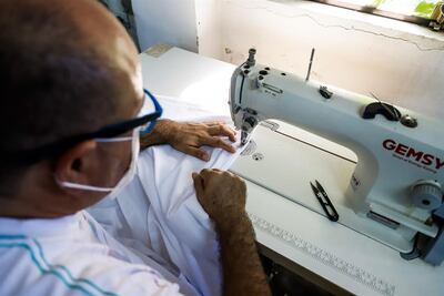 El costurero Mario Ozuna realiza los dobladillos de unas sábanas este martes.