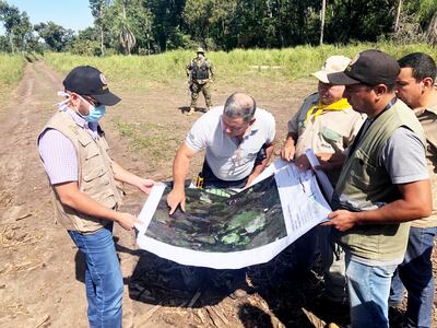 El ministro Ariel Oviedo y directores del Mades observan dentro del mapa del parque nacional el área deforestada.