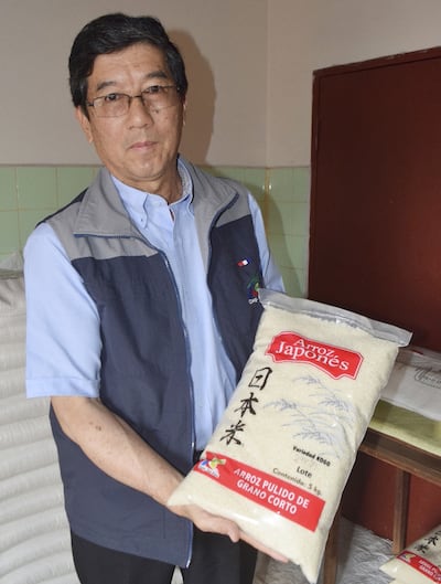 El gerente general de la Coop.  Agrícola La Paz, Bartolome Konishi, muestra una bolsa de arroz.