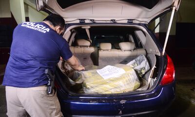 Un oficial del departamento Antinarcóticos de la Policía verifica una parte de la mercancía incautada en Villeta.