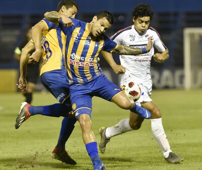 Los luqueños Aldo Quiñónez y Joel Benítez frenan la marcha del delantero albo David Fleitas, anoche en la victoria de Sportivo Luqueño sobre Nacional 2-0 en Villa Elisa.