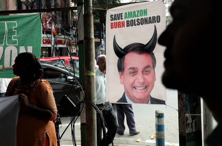 "Salven la Amazonia, quemen a Bolsonaro", dice este cartel frente a la embajada de Brasil en Calcuta, India.