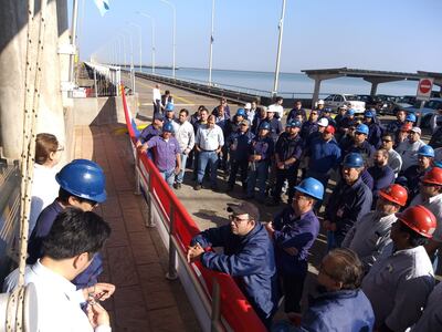 Funcionarios del departamento técnico frente a las zona de ingreso a la oficina de la Central Hidroeléctrica, aguardan la llegada de los directores de la Entidad Binacional Yacyretá para la firma del acuerdo.