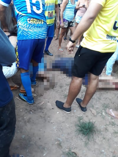 Varias personas observan los cuerpos de Julio César Rojas y Alejandro Malberti luego del ataque, en Bella Vista Norte.