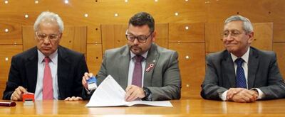 Marciano Torales, el procurador Sergio Coscia, y Freddie Pérez Tapia firmando el acuerdo.