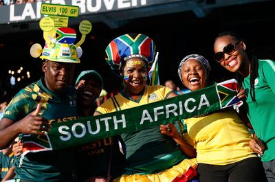 Hinchas de rugby sudafricanos posan con una bandera en apoyo a la selección nacional.