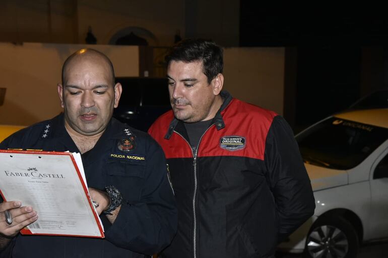 Abogado Rodrigo Flores (d) junto con un agente policial.