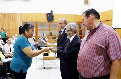 El ministro sustituto de Educación, Fernando Griffith, entrega el aporte a la directora de una de las instituciones educativas beneficiadas.