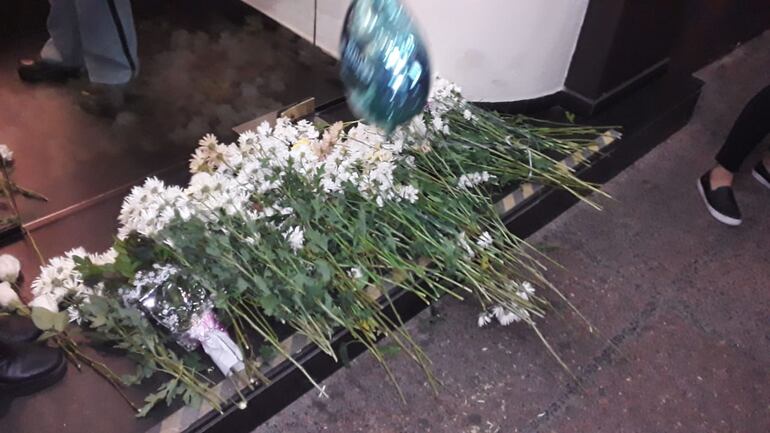 Flores dejadas por familiares y amigos de la familia de Renato, en la entrada de urgencias del Sanatorio Migone.