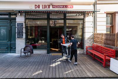 Los empleados de un restaurante llevan una mesa dentro antes de cerrar después de que el alcalde de la ciudad declarara un estado de emergencia para detener la propagación del nuevo coronavirus COVID-19 el 18 de marzo de 2020 en Halle / Saale, Alemania oriental.