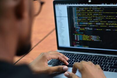 José Pino, hacker colombiano experto en ciberseguridad, revisa algunos códigos en su computador portátil durante una entrevista con Efe.