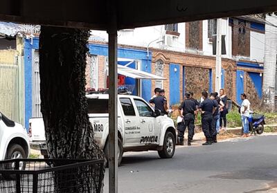 Efectivos policiales aguardan frente a la casa del  camerunés Gedeón Ndem A Ndem,  el momento de sacar el cuerpo.