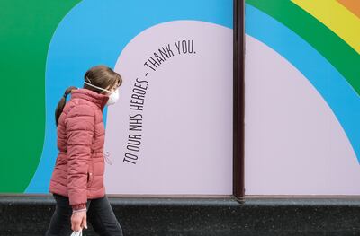 Una mujer con tapabocas lleva una bolsa de compras en Londres, Reino Unido.