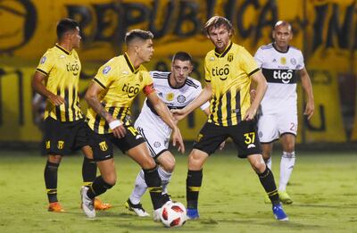 Alejandro Silva intenta sobrepasar la férrea marca aurinegra, con Fernández Cedrés y Walter Clar, en el mediosector.