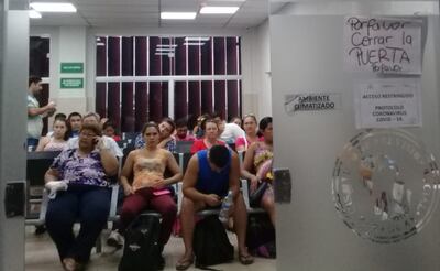 Familiares de internados aglomerados en el 2° piso del IPS, Obstetricia. En la puerta tiene pegado “protocolo covid-19”.