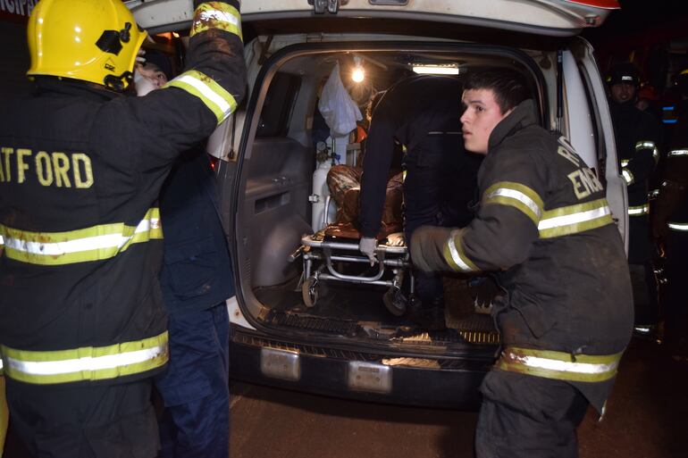 Los accidentados siendo asistidos por bomberos.