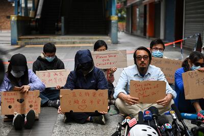 Familiares de estudiantes que tomaron la Universidad Politécnica de Hong Kong protestan en el distrito Hung Hom.
