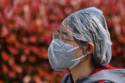 Una mujer con una máscara facial camina cerca de la estación de ferrocarril de Hankou en Wuhan.