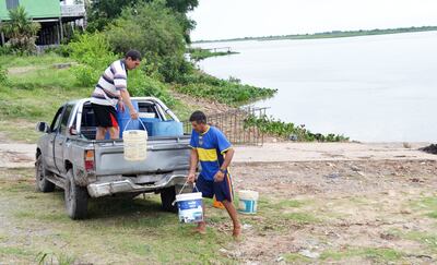 Los pobladores utilizan cualquier medio de transporte y recipientes para acarrear agua del río Paraguay a sus casas. La  provisión del vital está resentida desde hace 10 días.