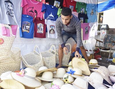 Alex Domínguez, de Luque,  muestra  sombreros y artesanías de karanda’y en su puesto, ubicado a metros de la basílica.